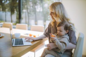 mom using laptop while holding baby