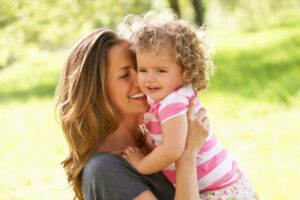 mom holding child in pink shirt